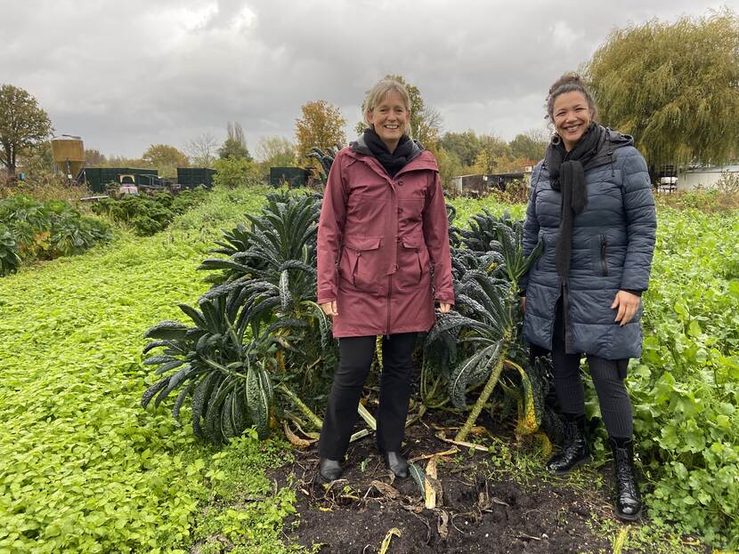 Twee vrouwen die staan in de Ecotuin