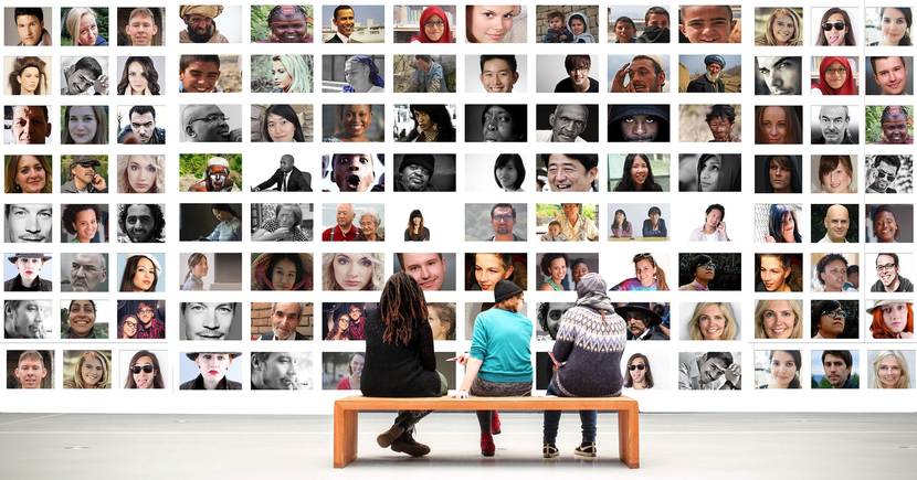 2 vrouwen en 1 man kijken zittend naar foto's van mensen